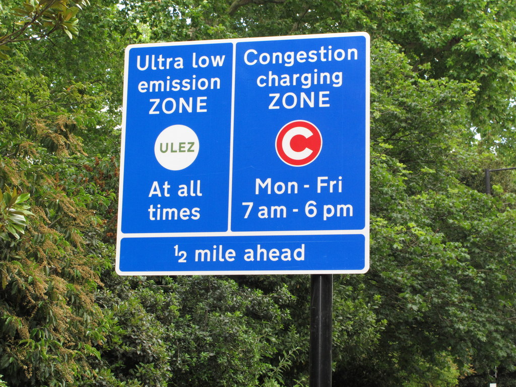En un cartel se avisa de que se entra en una zona de emisiones ultrabajas (ULEZ) y que de lunes a viernes, de 7:00 a 18:00, hay que pagar por entrar con un vehículo.